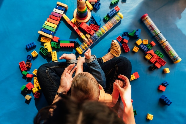 Child boy and mother playing with educational toy.