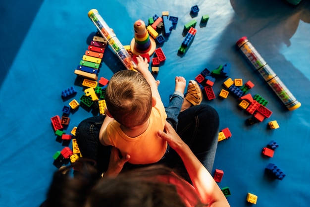 Child boy and mother playing with educational toy.