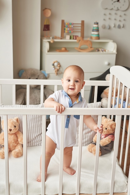 child boy plays wooden toys in a children's room in bright colors, Scandinavian style children's bedroom