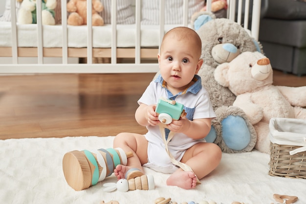 Child boy plays wooden toys in a children's room in bright colors, Scandinavian style children's bedroom