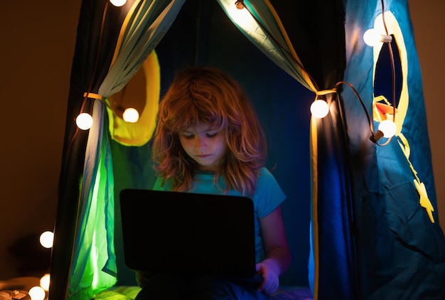 Child boy watching cartoons in bedroom at night little hacker young programmer