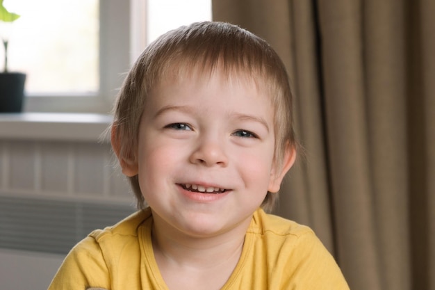 Child boy with blonde hair baby looking at camera Portrait 3 years old kid Boy toddler at home