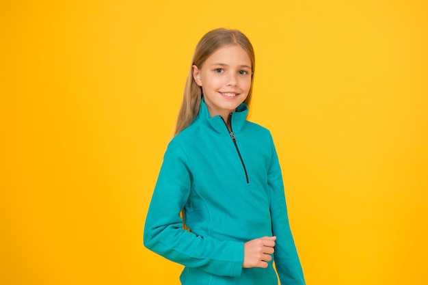 Child care concept Preteen girl smiling expression Adorable girl beautiful face Childrens shop store mall Goods for teens Upbringing and education Little girl Small child on yellow background