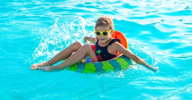 A child in a circle swims in the pool. Selective focus. Kid.