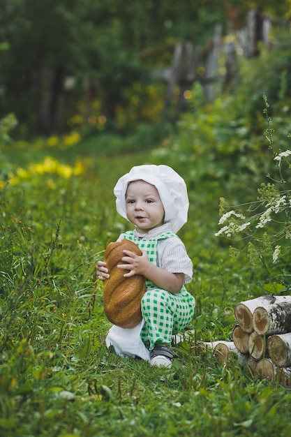 The child in the clothes of a Baker eats the loaf 4692