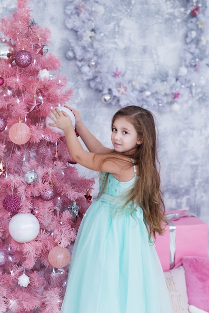 Child decorates the tree with Christmas balls