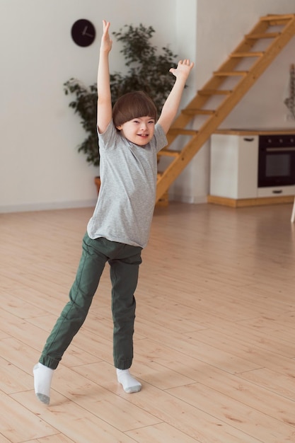 Child down syndrome playing or dancing at home