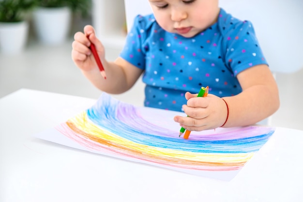 The child draws a rainbow Selective focus