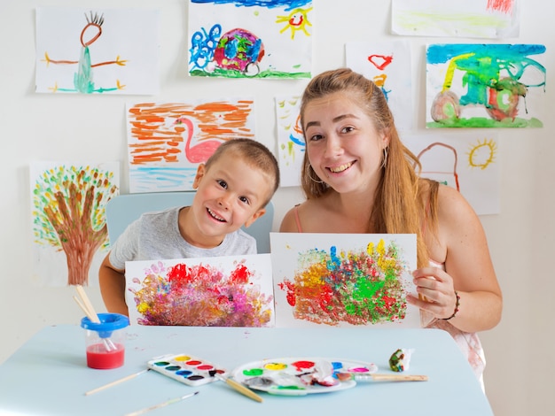 Photo child draws with teacher