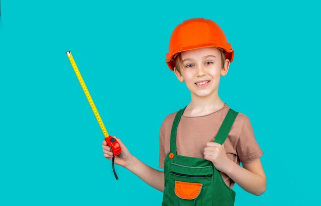 Child dressed as builder with ruller in hands Child dressed as a workman builder Little boy wearing helmet Little builder in hardhats building helmet hard hat Boy with a measuring tape