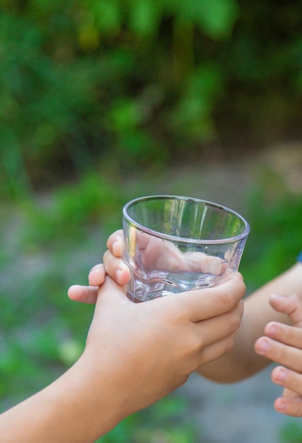 The child drinks water from a glass Selective focus