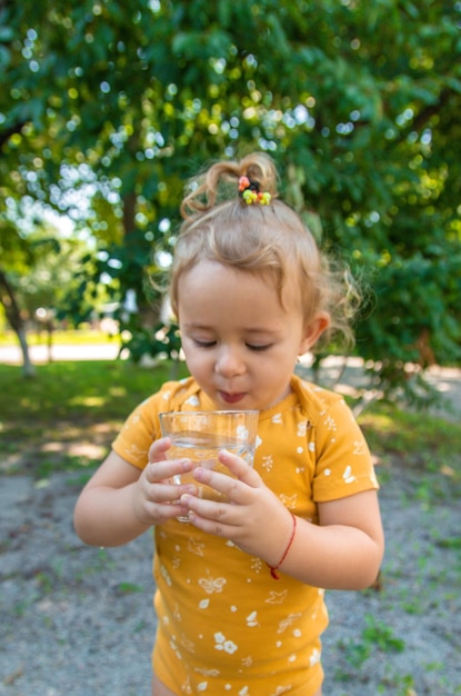 The child drinks water from a glass Selective focus