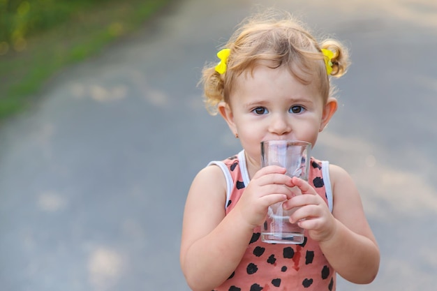 The child drinks water from a glass Selective focus