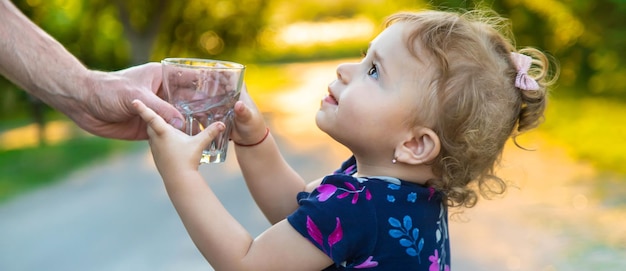 The child drinks water from a glass Selective focus