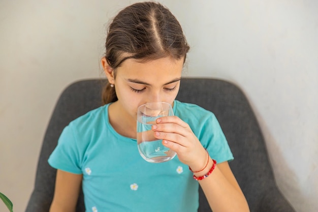 The child drinks water from a glass Selective focus