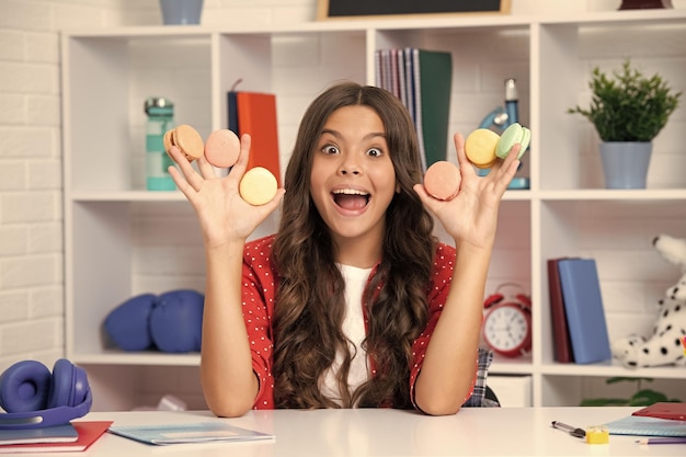 Child eat french macaron or macaroon cookies macaroons Excited face cheerful emotions of teenager girl