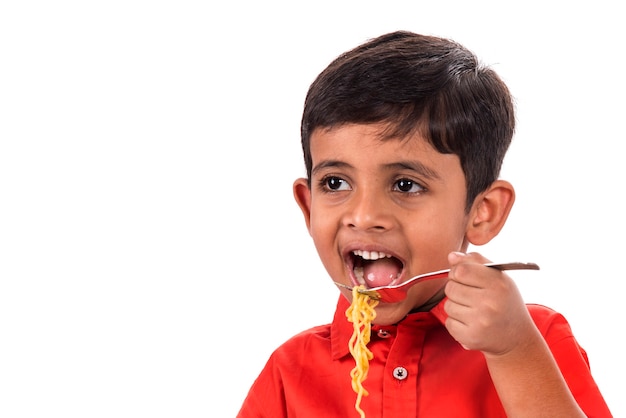 Child eating delicious noodle, Indian Kid eating noodles with Fork on White