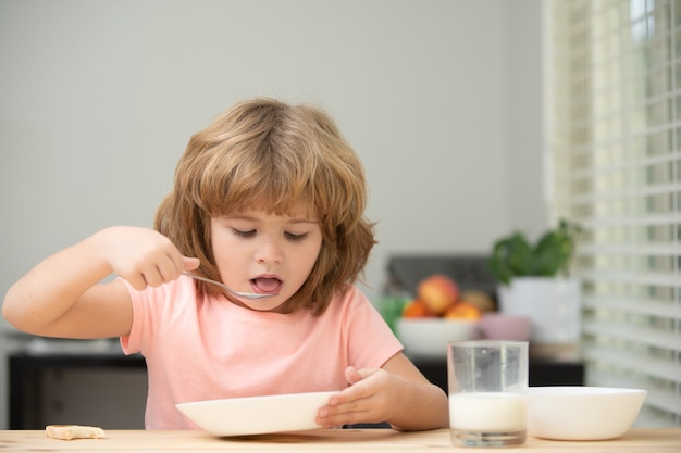 Child eating healthy food at home baby eat soup with spoon