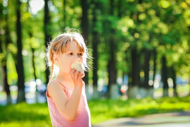 Child eating ice cream in the park on the background