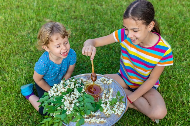 The child eats honey in the garden Selective focus