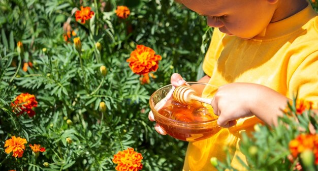 The child eats honey. Nature. Selective focus