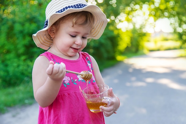 A child eats honey in the park Selective focus