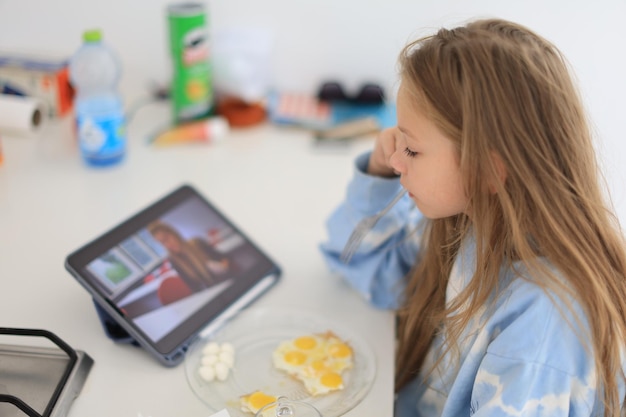 Child enjoys a healthy natural drink while having breakfast in kitchen at home Proper nutrition for children