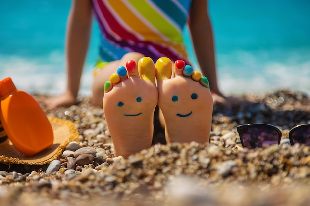 Child feet painted with paints on the sea. Selective focus.