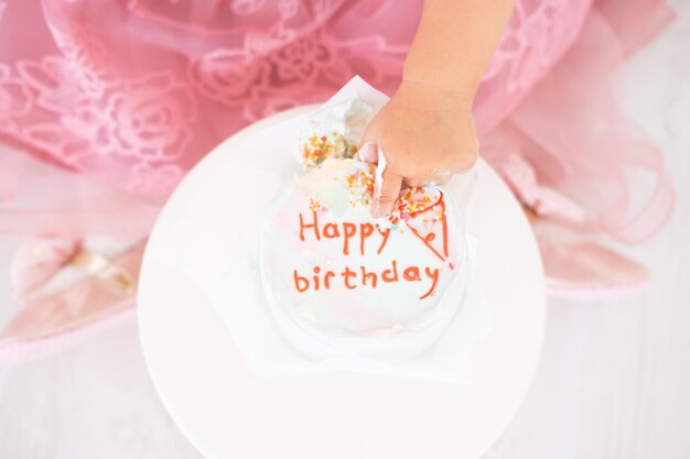 child finger in birthday cake, celebrate first birthday