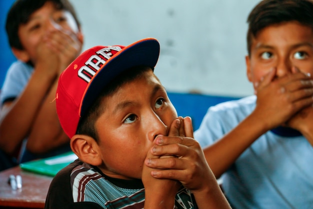 child from the peruvian highlands they play in a school dynamics covering their mouths