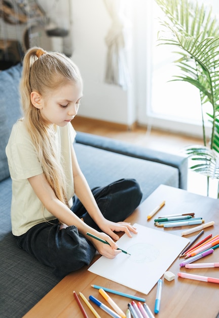 Child girl drawing with colorful pencils