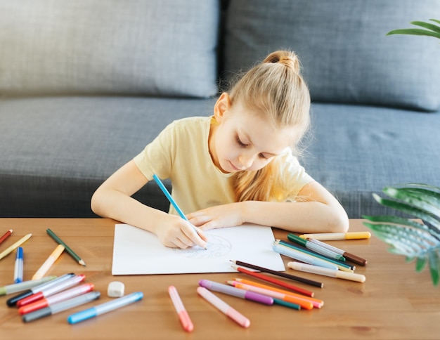 Child girl drawing with colorful pencils