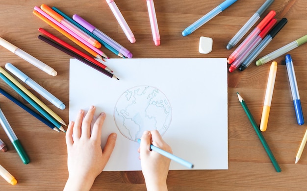 Child girl drawing with colorful pencils