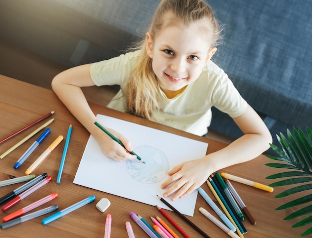 Child girl drawing with colorful pencils