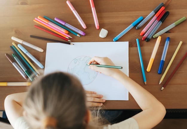 Child girl drawing with colorful pencils