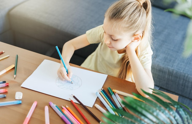 Child girl drawing with colorful pencils