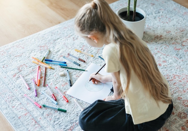 Child girl drawing with colorful pencils