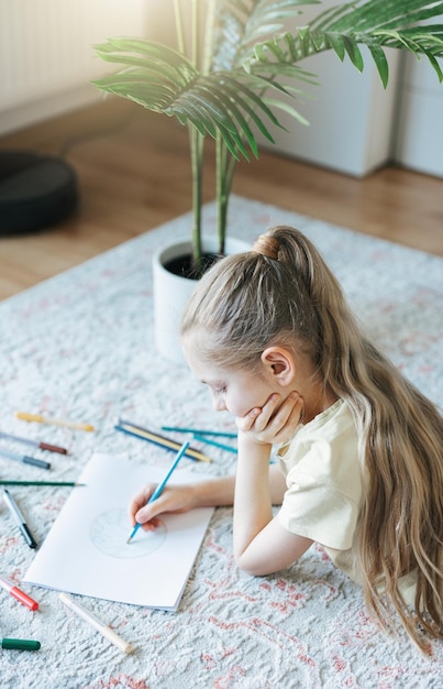 Child girl drawing with colorful pencils