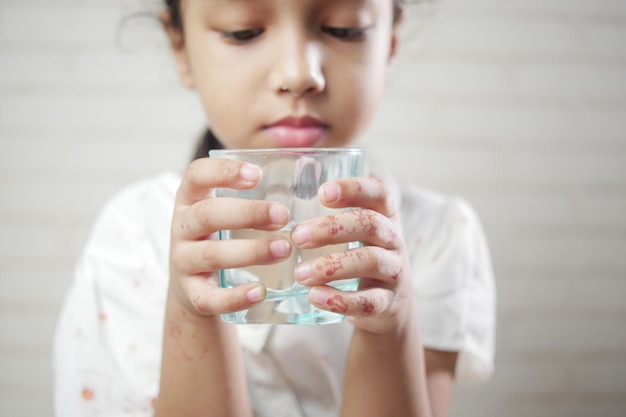 Child girl drinking milk while sited