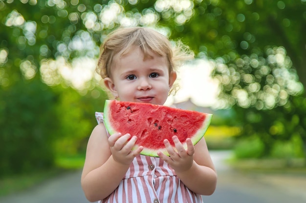 Child girl eats watermelon in summer Selective focus