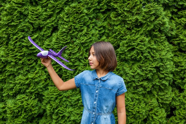 A child girl holds a toy plane in her hands