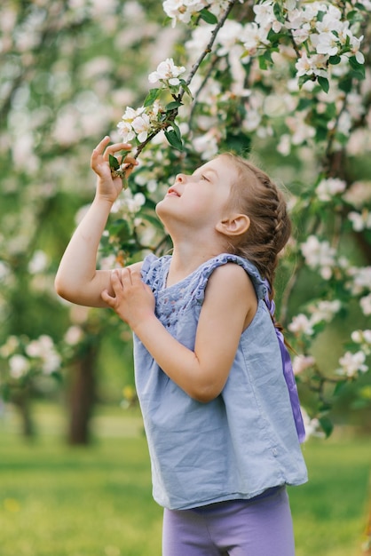 Child girl is fooling around in the park in the spring