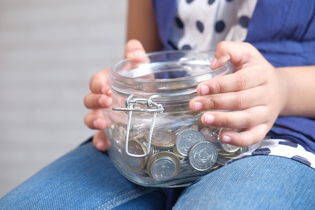 Child girl pile coin for saving close up