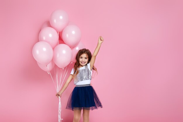 Child girl posing with pastel pink air balloons