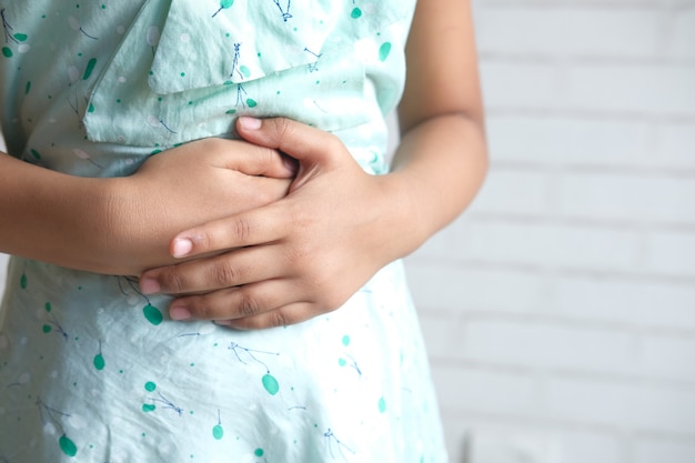 Child girl suffering stomach pain close up