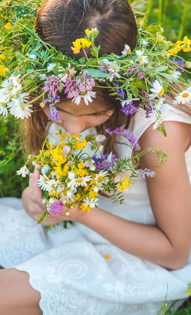 Child girl with wildflowers in summer Selective focus