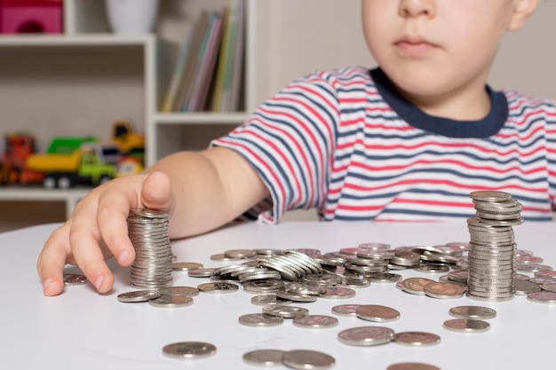 A child in glasses a young businessman plays with coins