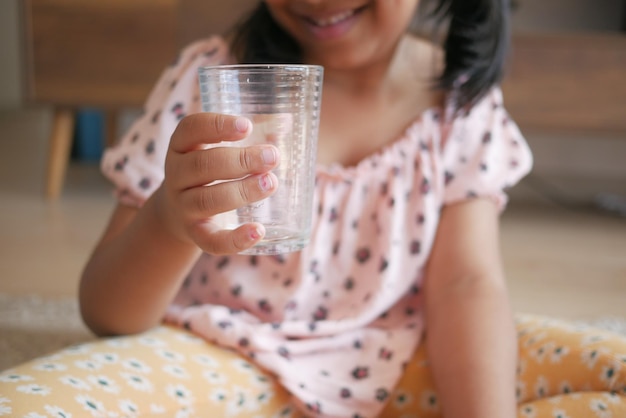 Child hand holding a glass of water