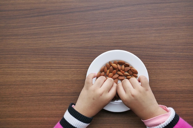 Child hand pick almond nuts