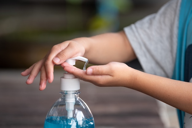 Child Hands Using Wash Hand Sanitizer Gel Pump Dispenser